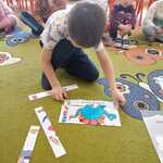 Filip układa puzzle z dinozaurem