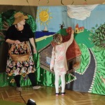 Krysia przyczepia kwiatek do scenografii