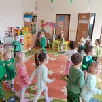 dzieci chodzą w sali z kwiatami