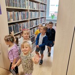 dzieci oglądają regały z książkami