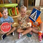 dzieci trzymają znaki drogowe