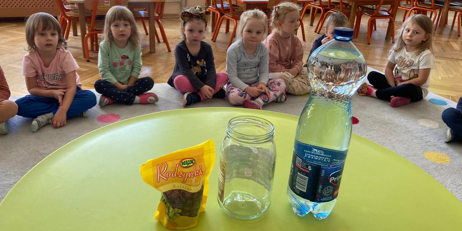 butelka, słoik i rodzynki na stoliku
