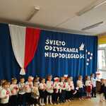 dzieci trzymają biało-czerwone flagi