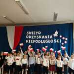 dzieci machają biało-czerwonymi flagami