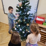 dzieci wieszaja bombki na choinkę