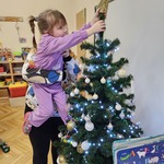 Basia wkłada gwiazdę na czubek choinki