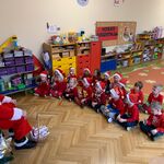 dzieci siedzą przed Mikołajem