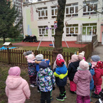 dzieci obserwują karmik zawieszony na gałęzi