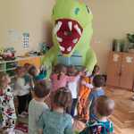 dzieci z dmuchanym dinozaurem