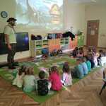 dzieci oglądają film o dinozaurach