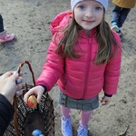 Julita wkłada pisankę do koszyka