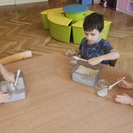 chłopcy nabierają łyżką perlit