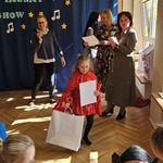 dziewczynka niesie dyplom i nagrody