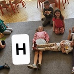 dziewczynki tworzą z ciał literę H
