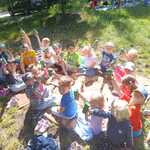 dzieci siedzą na kocach i trzymają soczki