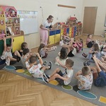 dzieci siedzą na podłodze z uniesionymi kończynami
