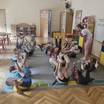 dzieci leża na plecach i unoszą kończyny do góry