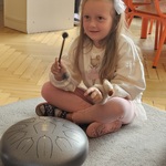 dziewczynka trzyma pałeczki do grania na instrumencie