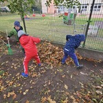chłopcy tworzą kopiec z liści