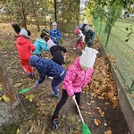 dzieci grabią opadłe jesienne liście