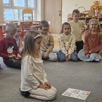 dziewczynka siedzi przy kartce z obrazkami