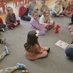 dziewczynki siedzą na dywanie obok robota