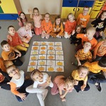 dzieci siedzą przy obrazkach dyni