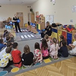 pani pokazuje dzieciom znak drogowy