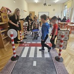 dzieci przechodzą przez jezdnię ze znakami