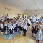 panie i dzieci śpiewają hymn w postawie stojącej