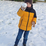chłopiec trzyma kulę śniegową
