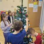 dzieci wieszają ozdoby na choince