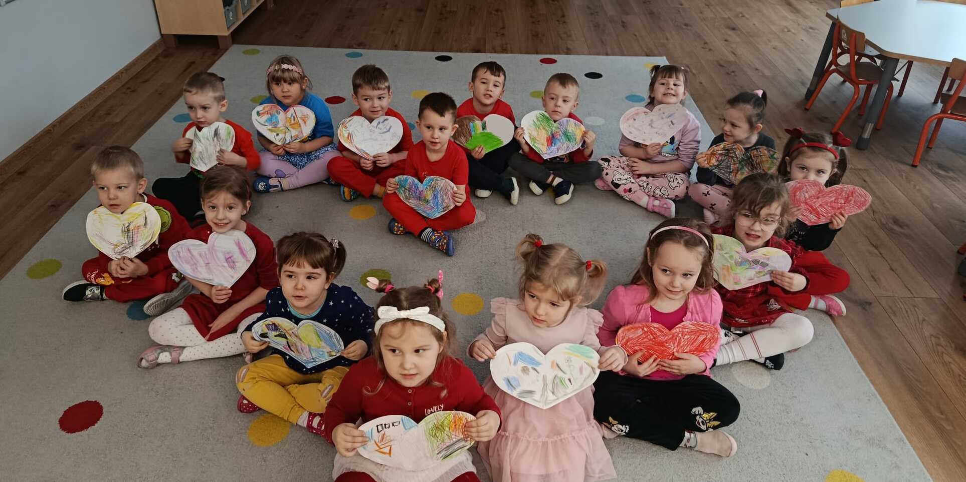 dzieci trzymają papierowe serca