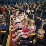 dzieci siedzą na fotelech w teatrze