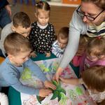 chłopiec przykleja palmę na kartkę