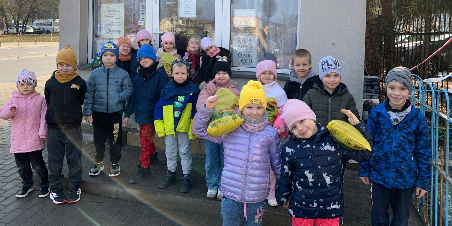dzieci trzymają ziemię do kwiatów