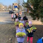 dzieci niosą worki z ziemią