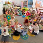dzieci trzymają grę i kwiatek