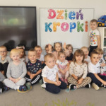 dzieci przy napisie dzień kropki